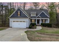 Charming single-Gathering home features a two-car garage, mature trees, and manicured lawn at 191 W Cultivator Way, Clayton, NC 27520