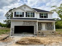 New two story home featuring white siding, black shutters, stone accents and an attached two car garage at 193 Falls Of The Cape Dr, Lillington, NC 27546