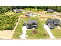 A stunning aerial view of a modern home with a well-manicured lawn and a private driveway at 20 Serenity Woods Trl, Franklinton, NC 27525