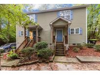 Charming duplex with light green siding, wood stairs, blue shutters, and well-maintained landscaping at 209 Mill St # A/B, Creedmoor, NC 27522