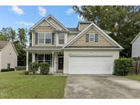 Charming two-story home featuring a two-car garage, well-manicured lawn, and inviting front porch at 2112 Queensway Ct, Creedmoor, NC 27522