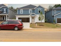 Charming two-story home with blue and white siding and an attached two-car garage at 2207 Cherry Creek Rd, Haw River, NC 27258