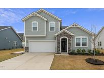 Charming two-story home with gray siding, stone accents, and a two-car garage at 235 Mallard Loop Dr, Clayton, NC 27527