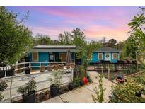 Charming blue house featuring solar panels and a lovely landscaped garden with potted plants and a cozy deck at 2801 Bethune Dr, Raleigh, NC 27603