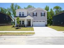 Charming two-story home featuring a two-car garage, manicured lawn, and inviting covered entry at 3849 Rosebush Dr, Zebulon, NC 27597