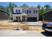 New two-story home featuring a mix of lap siding, an attached two-car garage and newly poured concrete driveway at 3849 Rosebush Dr, Zebulon, NC 27597