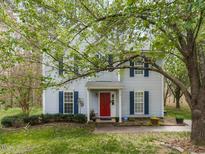 Charming two-story home featuring light-blue siding, blue shutters, and a vibrant red front door at 7 S Indiancreek Pl, Durham, NC 27703