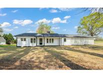 Charming white ranch home with black trim and a well-manicured lawn offers simple elegance at 8917 Fowler Rd, Zebulon, NC 27597