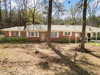 Charming single-story brick house featuring a covered carport and mature trees in a spacious front yard at 906 Perry Rd, Zebulon, NC 27597