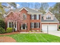 Beautiful two-story brick home with a well-manicured lawn and charming landscaping at 105 Fifemoor Ct, Cary, NC 27518