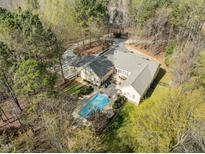 Stunning aerial view of a large home with a private pool and landscaped grounds surrounded by trees at 120 Teasel Ct, Clayton, NC 27527
