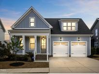 Charming blue two-story home with a two-car garage, landscaped front yard, and inviting entryway at 1905 Cedar Dam Ln, Wendell, NC 27591