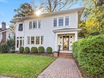 Charming two-story home with a brick walkway, well-manicured lawn, and beautiful landscaping at 2108 Myrtle Ave, Raleigh, NC 27608