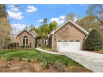Charming brick home featuring an attached two-car garage and lush landscaping, perfect for curb appeal at 2321 Mica Mine Ln, Wake Forest, NC 27587