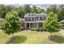 Beautiful two-story brick home with dormer windows, a manicured lawn, and mature landscaping at 2421 Trenton Park Ln, Raleigh, NC 27607