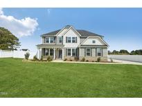 Charming two-story home with gray siding, black shutters, covered porch and a well manicured front lawn at 45 Pond Mountain Dr, Clayton, NC 27520