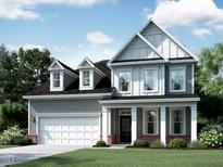 Two-story home featuring a two-car garage, covered entrance, dormer windows, and manicured landscaping at 5013 Aged Pine Rd # 53, Apex, NC 27523