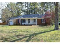 Charming one-story home featuring a brick facade, blue shutters, and a well-manicured front lawn at 5520 Mccormick Rd, Durham, NC 27713