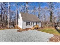 Charming white home featuring a gravel driveway and a well-maintained yard with a natural wooded backdrop at 612 Miller Rd, Hillsborough, NC 27278