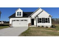 Charming white home featuring a two-car garage, black shutters, and a well-manicured lawn at 77 Heatherglenn Cir, Princeton, NC 27569