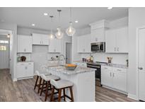 Beautiful kitchen featuring granite counters, stainless appliances, pendant lighting, and stylish island at 88 Baldwin St, Lillington, NC 27546
