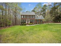 Charming brick two-story home with manicured lawn and mature trees, offering a picturesque curb appeal at 10605 Marabou Ct, Raleigh, NC 27614