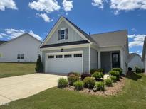 Charming one-story home with a two-car garage, landscaped yard, and a beautiful blue sky backdrop at 107 Canary Ct, Raleigh, NC 27610