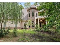 Charming stone and siding home featuring a turret, covered entrance, and lush landscaping at 1217 Mauldin Rd, Wake Forest, NC 27587