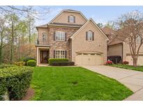 Charming home with a well-manicured lawn, brick and stone facade, and a two-car garage at 144 Arabella Ct, Cary, NC 27518