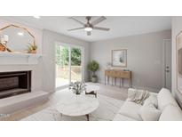 Bright living room featuring a brick fireplace, ceiling fan, and sliding glass doors to the deck at 206 Woods Run, Knightdale, NC 27545