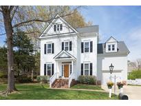 Charming white two-story home with black shutters, brick walkway, manicured lawn, and flower decor at 2061 Carriage Way, Chapel Hill, NC 27517