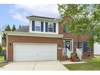 Charming brick home featuring a white garage door, blue shutters, and a welcoming front entrance at 2310 Nutting Ln, Apex, NC 27523