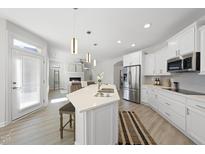 Bright, open kitchen featuring an island with a sink, stainless steel appliances, and a view of the living room at 301 Crayton Oak Dr, Cary, NC 27519