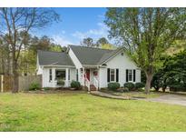 Charming single-Gathering home featuring a manicured lawn, inviting entryway, and classic architectural details at 3708 Turnbull Ct, Raleigh, NC 27616