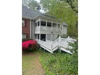 Exterior view of condo with latticework balcony, white picket fence, and lush landscaping at 411 Gooseneck Drive # B6, Cary, NC 27513