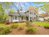 Charming home with a well-maintained lawn, mature trees, and a cozy front porch at 516 Edinburgh Dr, Burlington, NC 27215