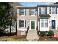 Charming two-story townhome featuring beige siding, green shutters, and a welcoming front entrance with a green door at 5551 Vista View Ct, Raleigh, NC 27612