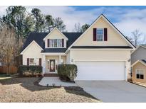 Charming yellow home featuring well-maintained landscaping, a two-car garage and a welcoming entryway at 605 Lakeview Ave, Wake Forest, NC 27587