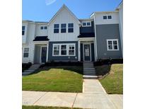 Charming townhome with well-manicured lawn and inviting front entrance on a sunny day at 609 Callan View Ave, Wake Forest, NC 27587