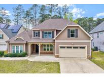 Charming two-story home with brick accents, attached two-car garage and manicured front lawn at 8932 Buffalo Gourd Ln, Angier, NC 27501