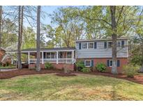 Charming two-story home with brick facade, white trim, a covered porch and beautiful landscaping at 927 Ferncrest Dr, Durham, NC 27705