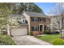 Charming two-story home with a brick facade, a well-manicured lawn, and blossoming trees at 102 Swallow Hill Ct, Cary, NC 27513