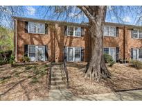 Charming brick townhome featuring a welcoming entrance with stairs and mature tree at 103 Friar Ln, Carrboro, NC 27510