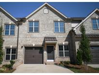 Charming two-story townhome featuring a brick facade, garage, and inviting front entrance at 1051 Beechcraft Dr # 123, Mebane, NC 27302