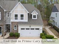 Charming end-unit townhome featuring stone accents, attached two-car garage, and manicured landscaping at 111 Wards Ridge Dr, Cary, NC 27513