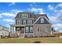 Charming two-story home showcasing a mix of stone and siding with a welcoming front porch at 1160 Duke Farm Dr, Wake Forest, NC 27587