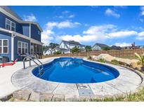 Backyard in-ground pool with stamped concrete edge and surrounding fence offers privacy and a spot to relax at 1160 Duke Farm Dr, Wake Forest, NC 27587