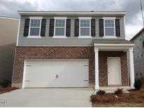 Charming two-story home with a brick facade, attached garage, and inviting front entrance at 1165 Solace Way, Rolesville, NC 27571
