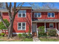 Charming townhouse with red siding, manicured landscaping, and inviting front porch at 125 Long Shadow Pl, Durham, NC 27713