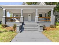 Charming front porch with gray stairs, railings, and white columns offers a welcoming entrance at 129 Burwell Avenue Ave, Henderson, NC 27536